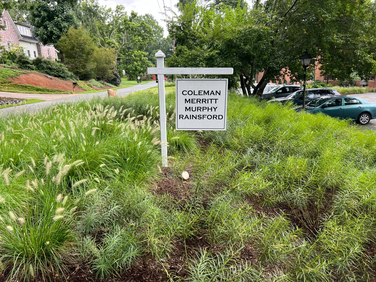 Coleman Merritt office sign framed by ornamental grass