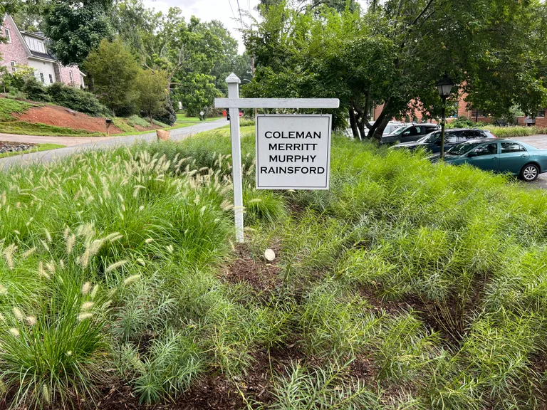 Coleman Merritt office sign framed by ornamental grass